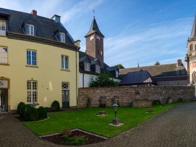 Zu sehen ist das gelbe Haus Thomas auf der linken Seite des Bildes. Weiter im Hintergrund ist der Xantener Dom zu sehen. Der Himmel ist schön blau.