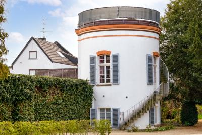 Turm am Westwall. Der Turm ist ein Rundes Gebäude mit Weißer Fassade und flachem Dach